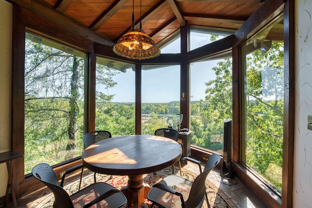 sunroom featuring a healthy amount of sunlight, vaulted ceiling with beams, and wooden ceiling