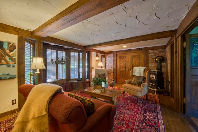 living room featuring a wood stove, beam ceiling, and wood-type flooring