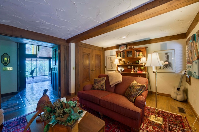 living room featuring hardwood / wood-style flooring and beamed ceiling