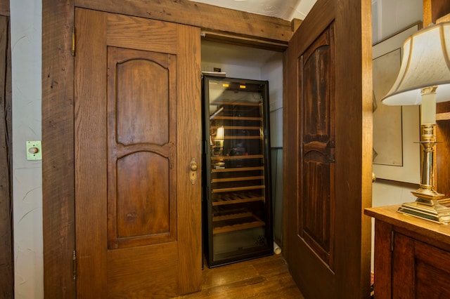 wine cellar with beverage cooler and dark hardwood / wood-style flooring