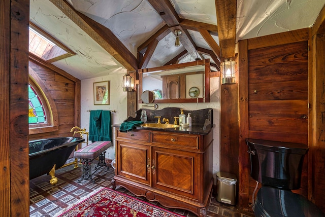 bathroom with lofted ceiling with beams, a tub, and vanity