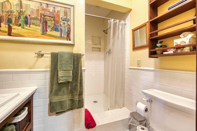 bathroom with curtained shower, tile walls, vanity, and toilet