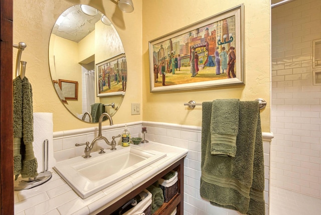 bathroom featuring tile walls, vanity, and curtained shower