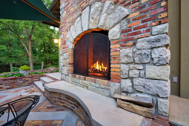 property entrance with a patio area and an outdoor stone fireplace