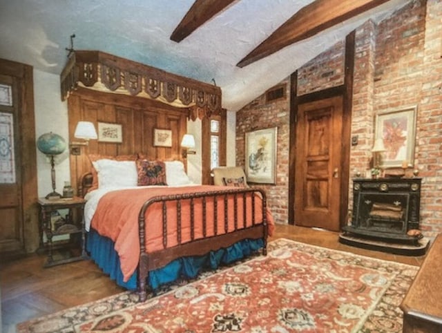 bedroom with ceiling fan, vaulted ceiling with beams, hardwood / wood-style flooring, and brick wall