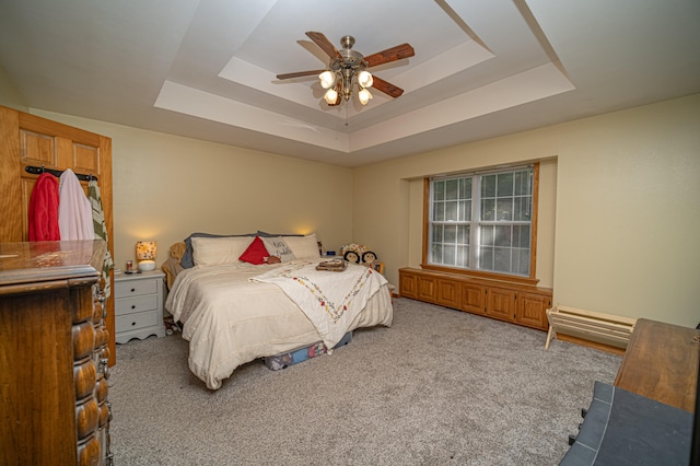 bedroom with a tray ceiling, carpet, and ceiling fan