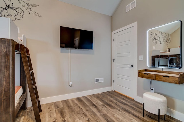 interior space featuring wood-type flooring and vaulted ceiling