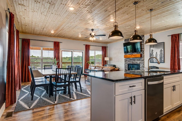 kitchen with wood ceiling, decorative light fixtures, sink, a stone fireplace, and white cabinets