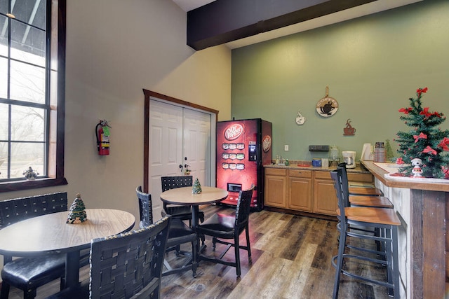 dining space featuring dark wood-type flooring, sink, and a towering ceiling