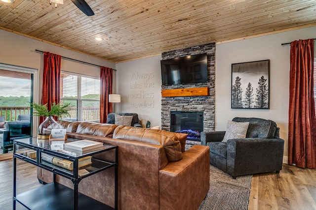 living room with wood-type flooring, a fireplace, ceiling fan, and wooden ceiling