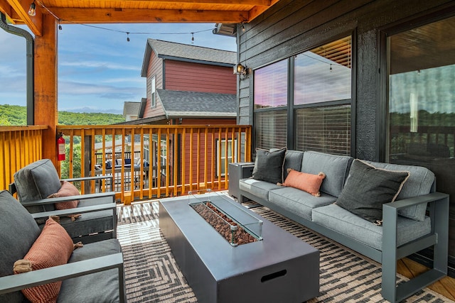 deck with an outdoor living space with a fire pit