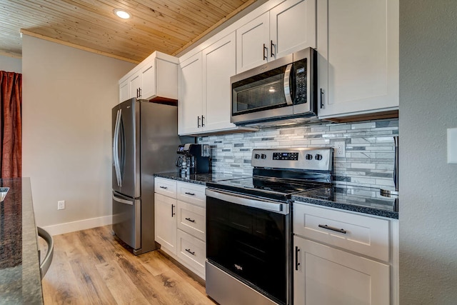 kitchen with dark stone countertops, white cabinets, and appliances with stainless steel finishes