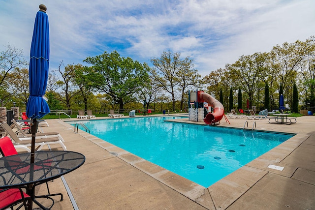 view of swimming pool featuring a water slide and a patio area