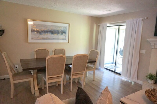 dining area featuring a textured ceiling and light hardwood / wood-style floors