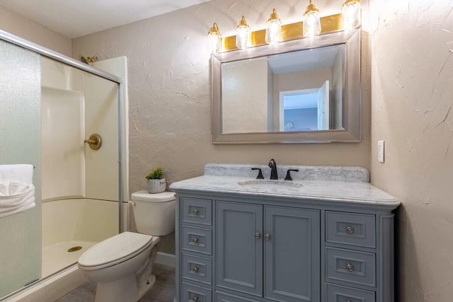 bathroom featuring an enclosed shower, toilet, and vanity