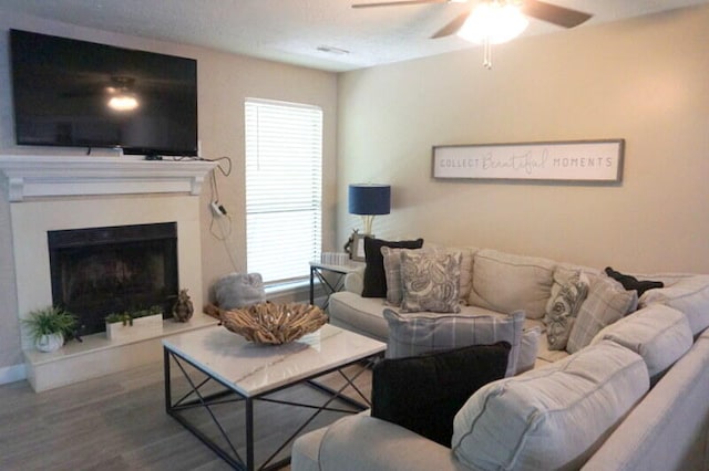 living room with wood-type flooring and ceiling fan