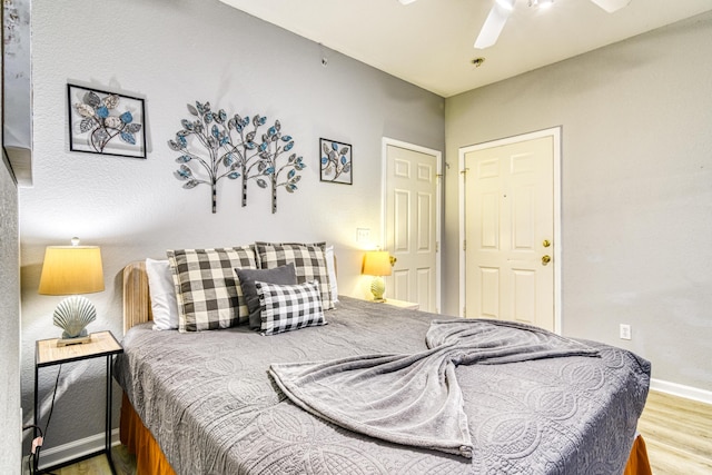 bedroom featuring wood finished floors, baseboards, and ceiling fan