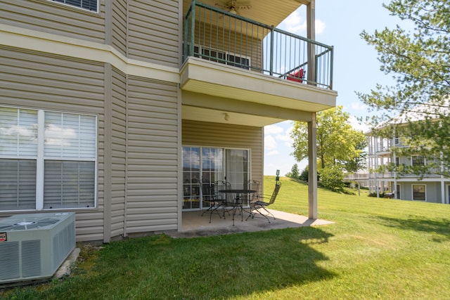 exterior space featuring cooling unit, a balcony, a lawn, and a patio area