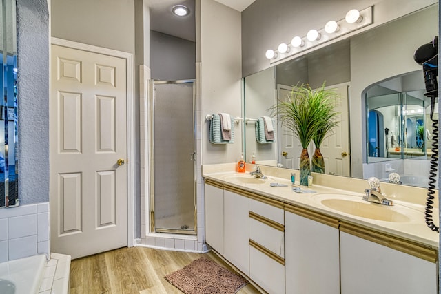 bathroom with independent shower and bath, vanity, and hardwood / wood-style floors