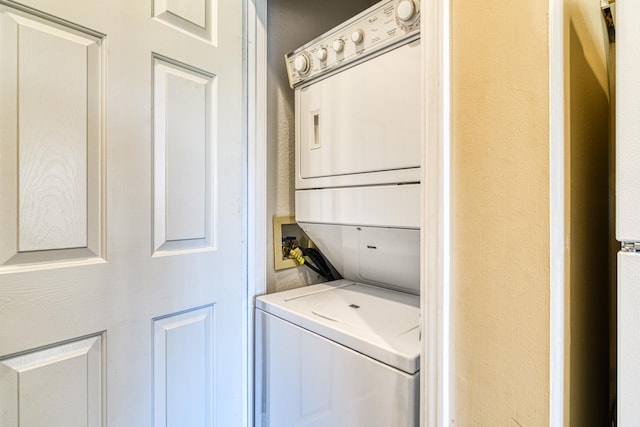 laundry room featuring stacked washer / drying machine