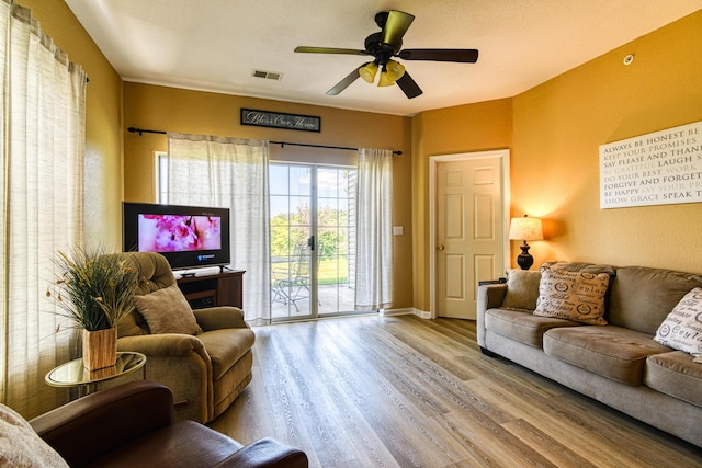 living area featuring ceiling fan, baseboards, wood finished floors, and visible vents