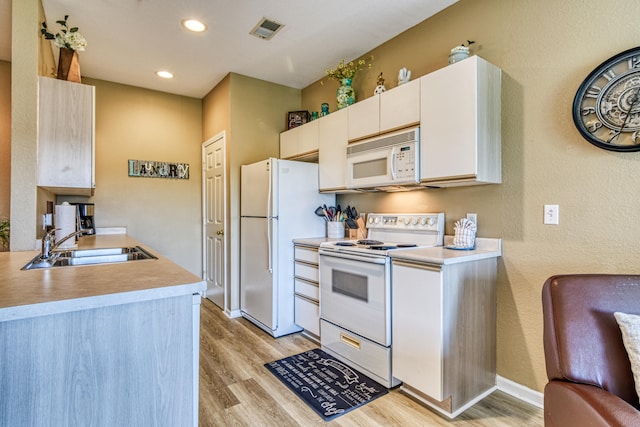 kitchen featuring light wood-type flooring, white cabinetry, white appliances, and sink