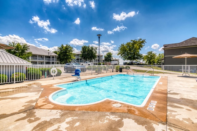 pool featuring fence and a patio