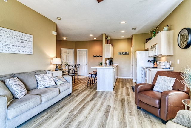 living area with recessed lighting, light wood-style floors, and visible vents