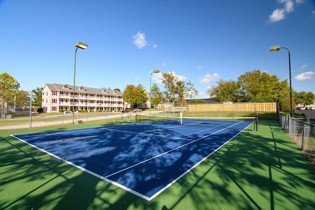 view of tennis court featuring fence