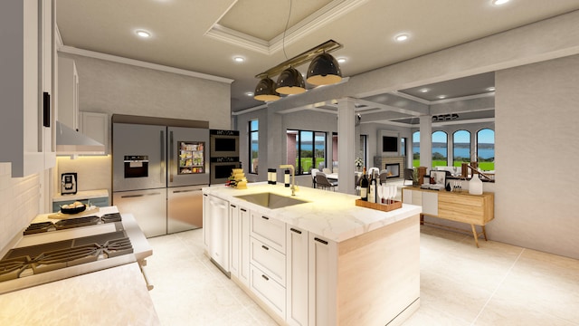 kitchen with an island with sink, light stone counters, a wealth of natural light, and stainless steel appliances