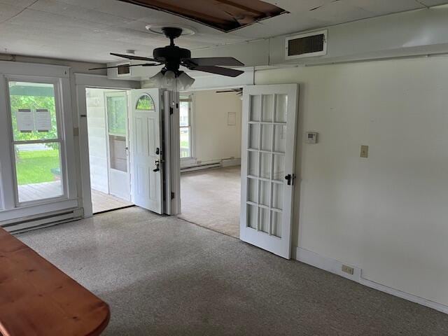 empty room featuring french doors, ceiling fan, and a baseboard radiator