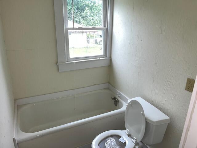 bathroom with a tub and toilet