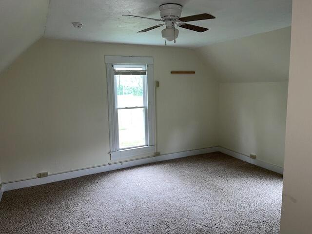 additional living space with ceiling fan, carpet floors, and vaulted ceiling