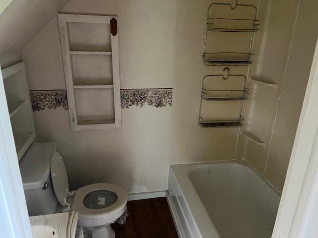 bathroom with lofted ceiling, a tub, hardwood / wood-style flooring, and toilet