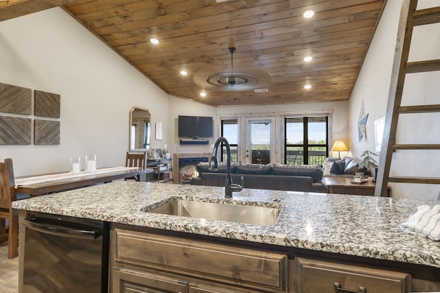 kitchen with wood ceiling, lofted ceiling, light stone countertops, and sink