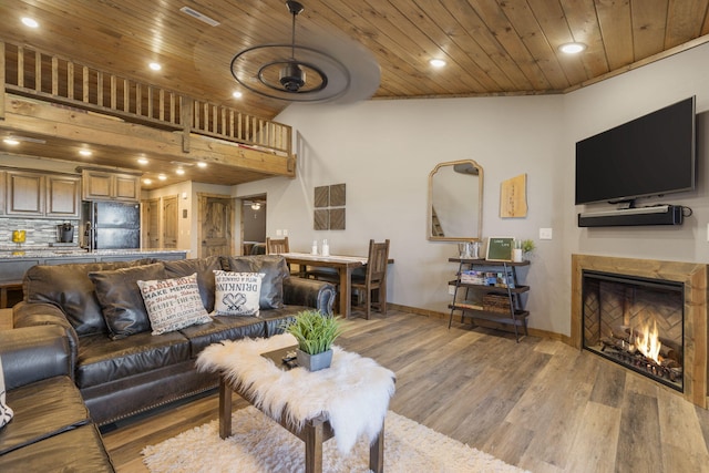 living room featuring wooden ceiling, a high ceiling, and light wood-type flooring