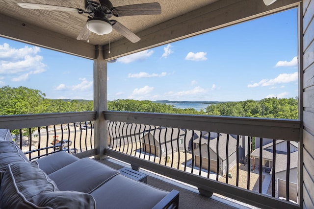 balcony with a water view and ceiling fan