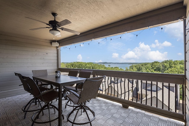 exterior space featuring ceiling fan and a water view