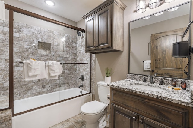 full bathroom with vanity, shower / bath combination with glass door, and toilet