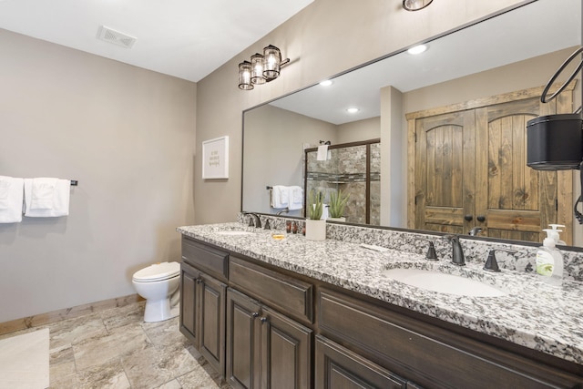 bathroom with vanity, toilet, and a shower with shower door