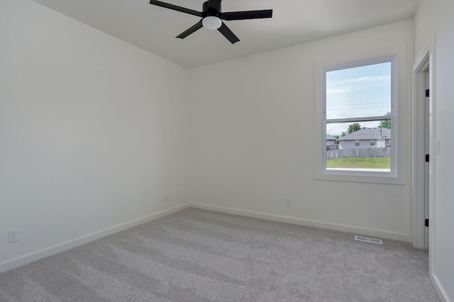 carpeted spare room featuring ceiling fan