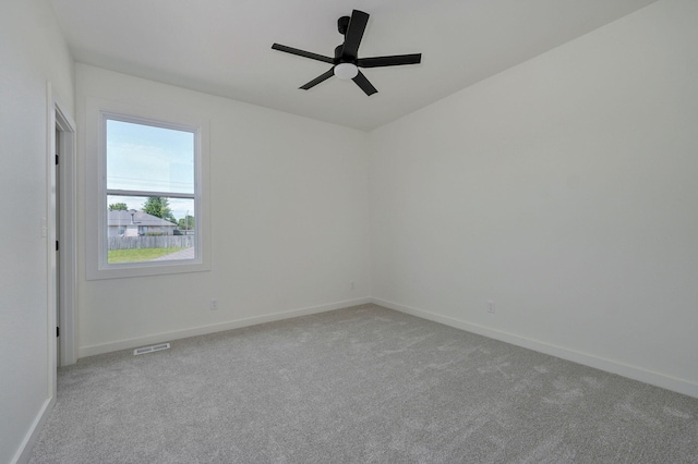 carpeted spare room featuring ceiling fan