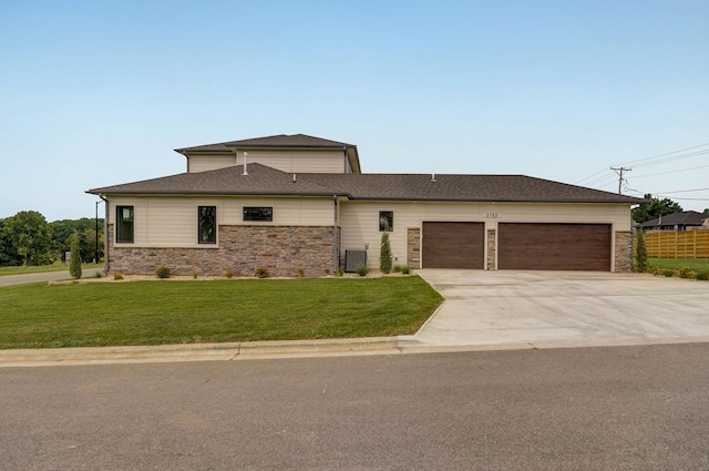 view of front facade featuring a garage, a front yard, and cooling unit