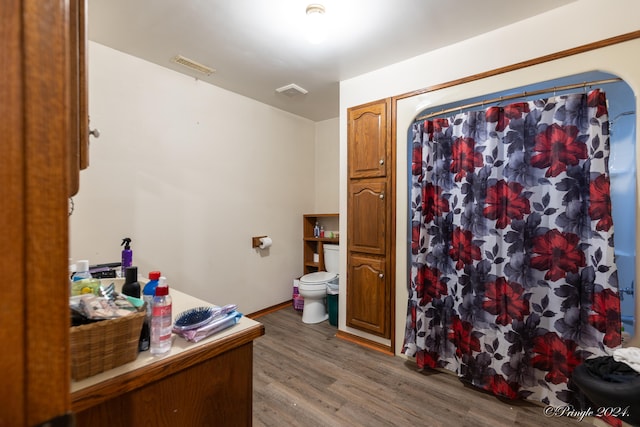 bathroom featuring a shower with shower curtain, hardwood / wood-style flooring, and toilet