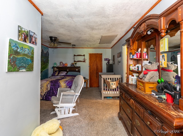 carpeted bedroom with ornamental molding, ceiling fan, and a textured ceiling