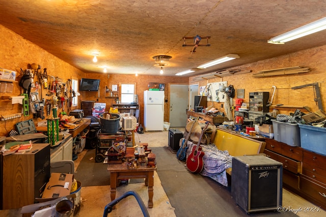 garage with a workshop area and white fridge