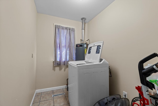 clothes washing area with gas water heater, light tile patterned floors, and washer and clothes dryer