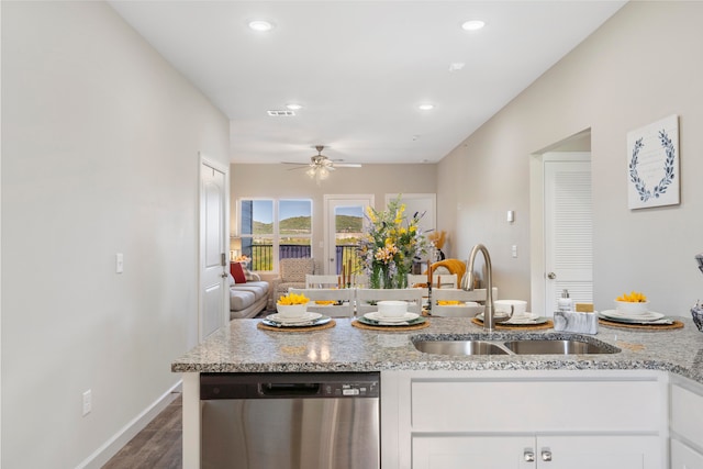 kitchen with sink, dishwasher, light stone countertops, dark hardwood / wood-style floors, and white cabinets