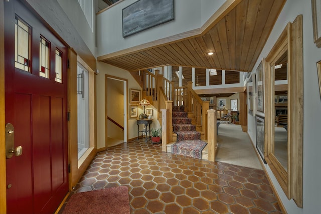 entryway with wood ceiling and a high ceiling