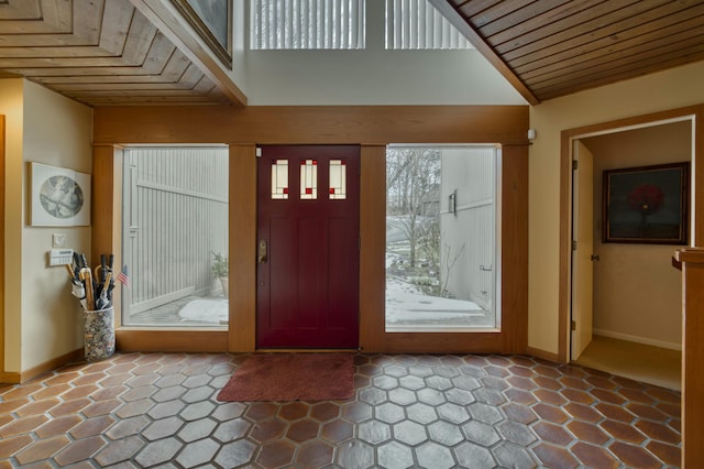 foyer entrance featuring a high ceiling and wooden ceiling